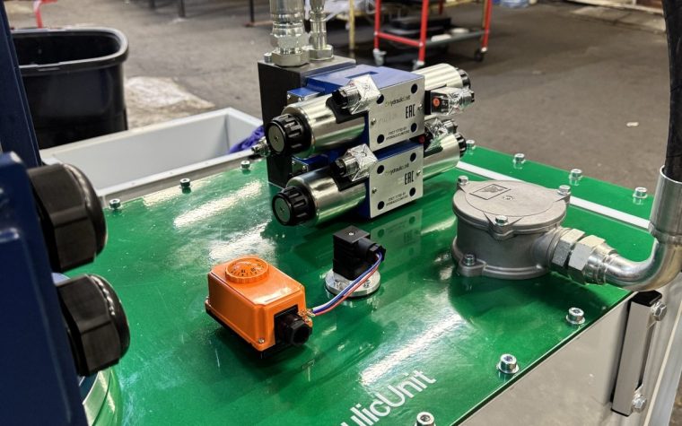 Блок управления на плите маслостанции HydraulicUnit: гидрораспределители с электромагнитными катушками и датчик уровня и температуры масла